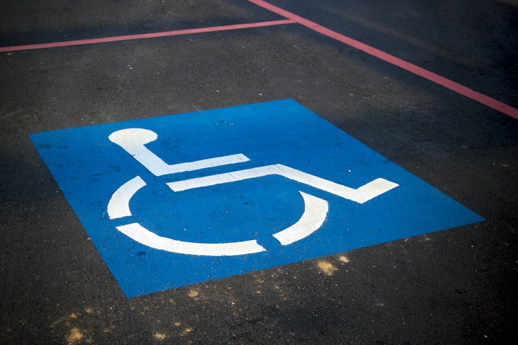 Inspector checking accessibility ramp for compliance with mobility standards