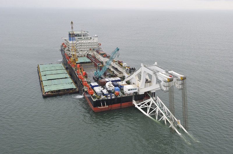 Crane barge on open water where rigorous maritime inspection is conducted using digital devices to ensure vessel safety