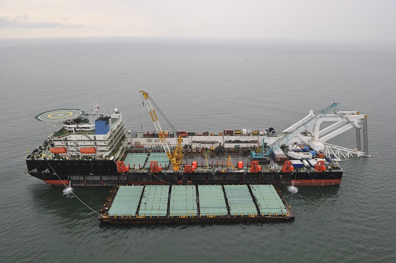Crane and barge at port representing container logistics and asset inspection operations