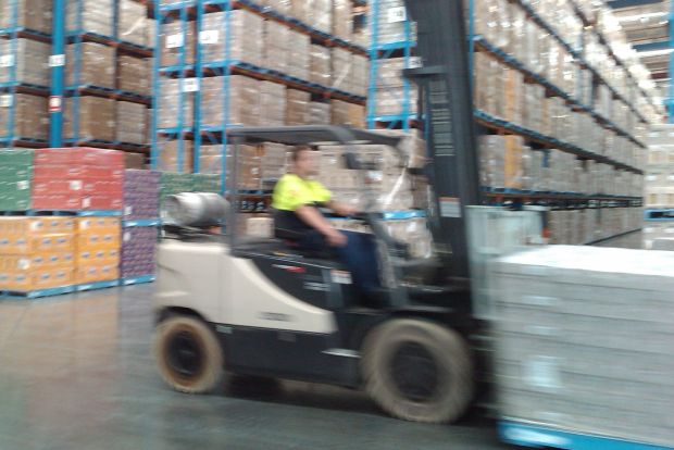 Forklift operator in a warehouse environment where ISO 45001 occupational health and safety standards apply