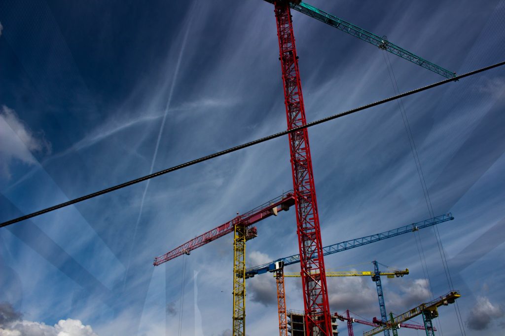 Lifting equipment including chains and hooks being inspected with a digital tablet in an industrial setting