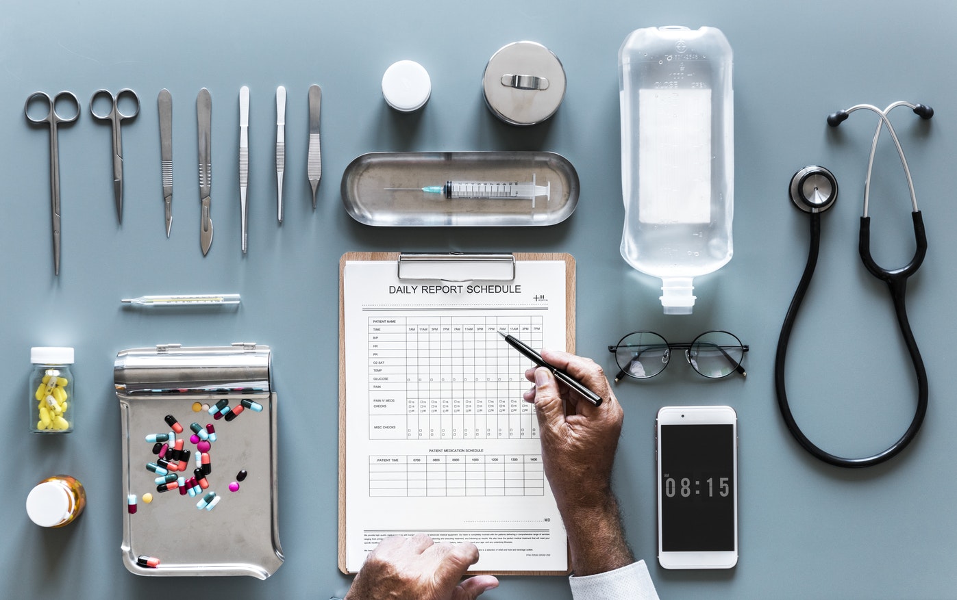 Biomedical technician using a digital checklist on a tablet to manage medical equipment in a hospital setting
