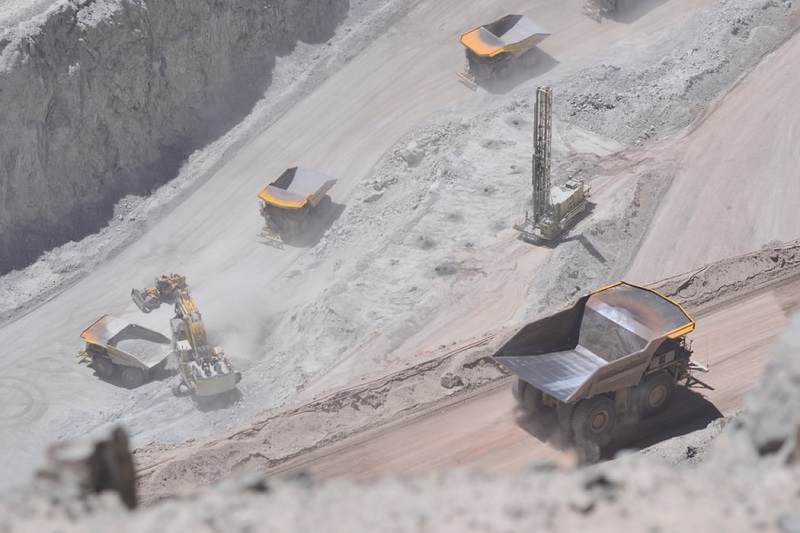 Large mining trucks operating on a mountain mine site road