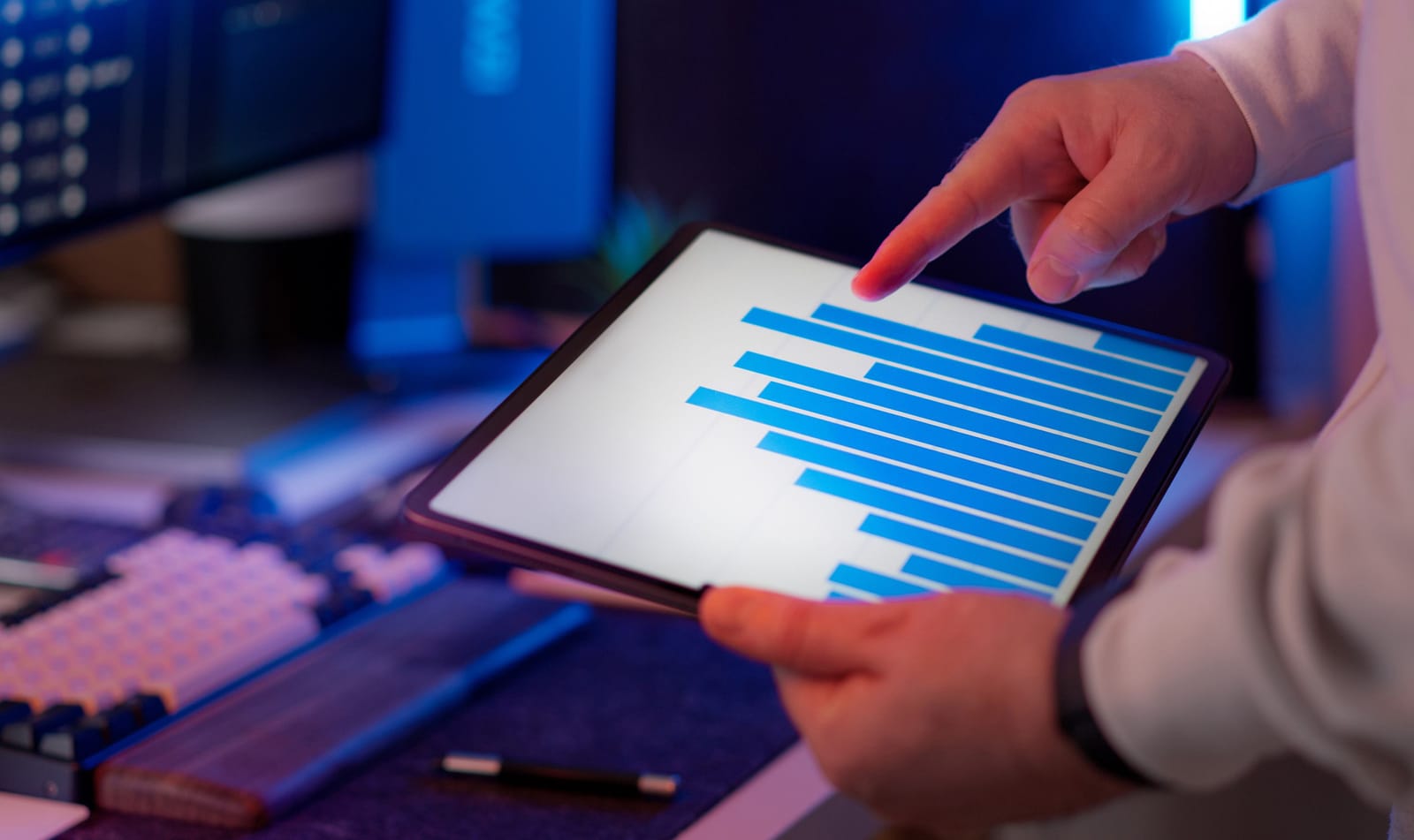 Person pointing at a blue bar chart of inspection results on a tablet screen